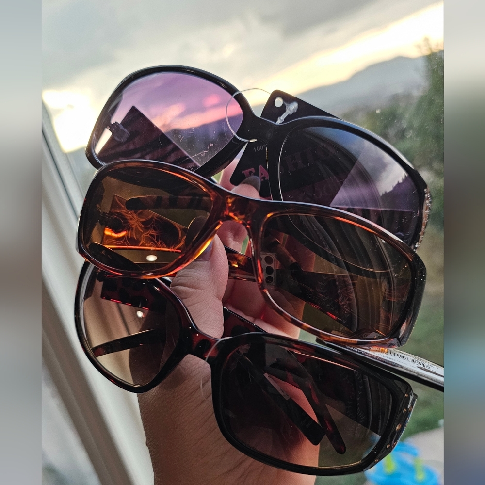 3 pair of new with tags sunglasses. One foster grant tag says 21.99 two others $
